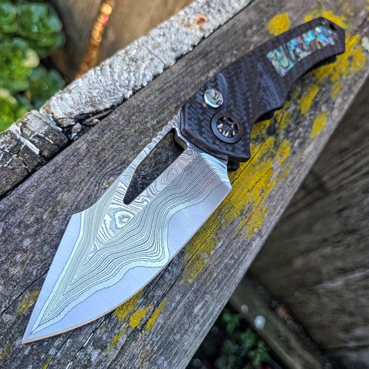 Heretic Knives Pariah Manual Hnd Ground VF Wood Grain San Mai Carbon Fiber Abalone Folder