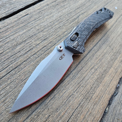 Folding knife with a textured handle on a wooden surface