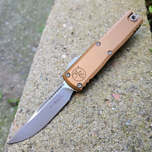 Folding knife with a brown handle on a concrete surface