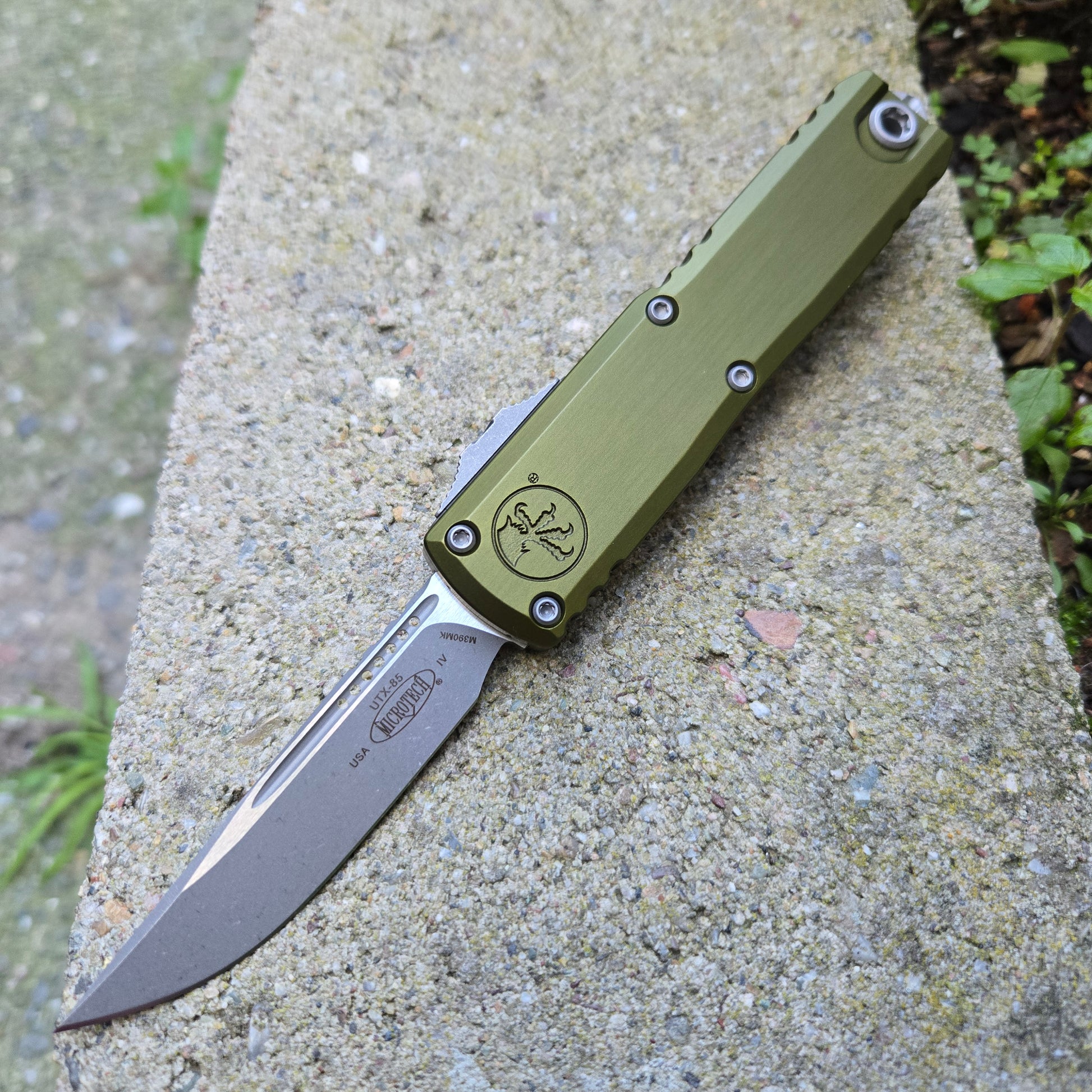 Green folding knife on a concrete surface