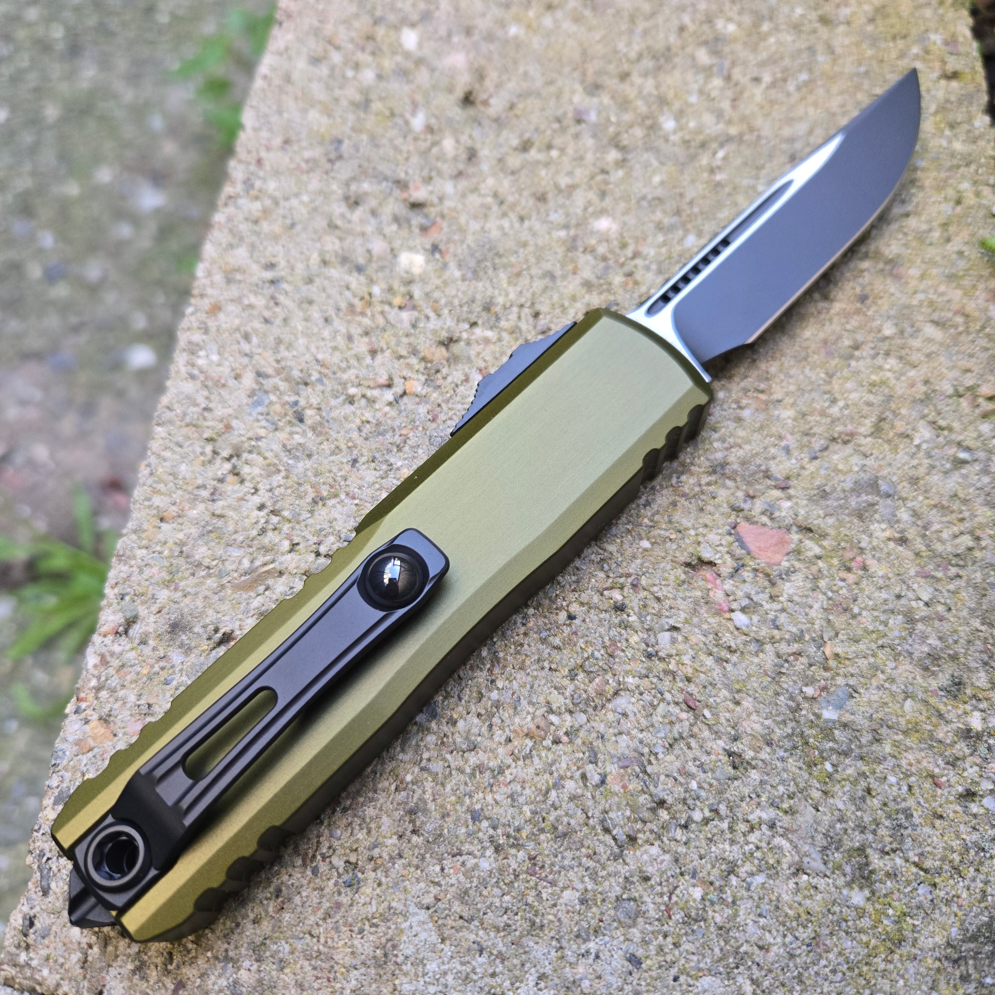 Green folding knife on a textured surface