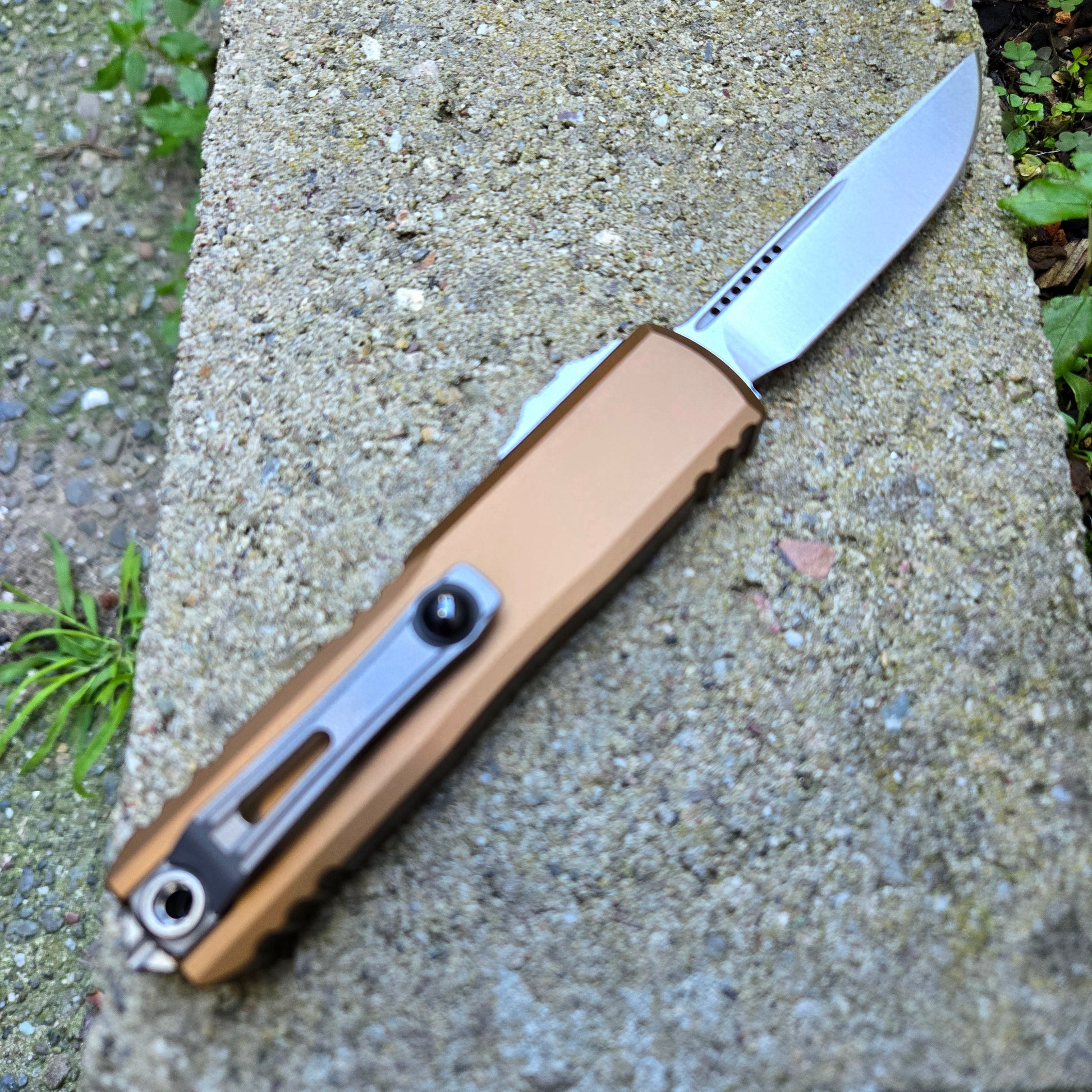 Folding knife with a brown handle on a concrete surface