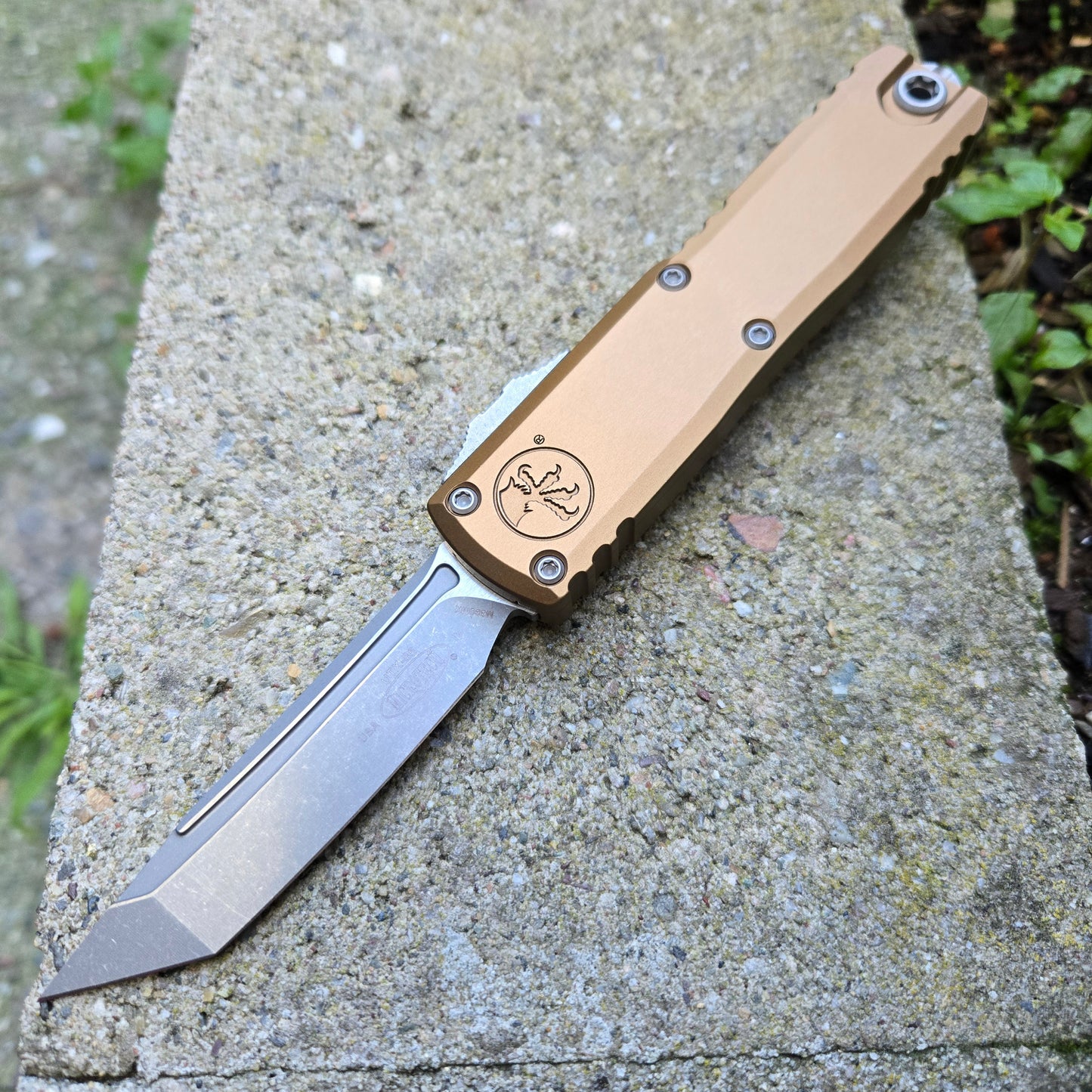 Folding knife with a beige handle on a concrete surface
